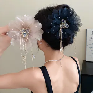 Detailed view of elegant chiffon flower hair claw clip with long tassels and rhinestones.