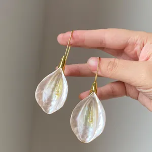 Hand-held elegant calla lily petal earrings featuring gold hooks and pearlescent finish