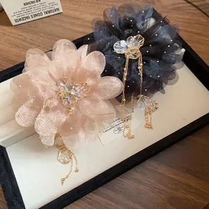 Close-up detail of elegant chiffon flower hair claw clips with rhinestones and tassels