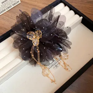 Elegant black chiffon flower hair claw clip with golden tassels and acrylic center piece.