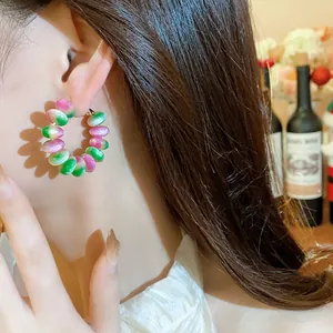 Primer plano detallado de pendientes de aro de cuentas de resina de colores estilo dopamina en oreja