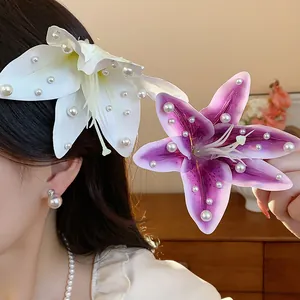Gros plan détaillé sur des pinces à cheveux lys en tissu avec perles en blanc et violet.