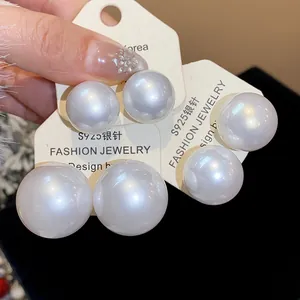 Primo piano di eleganti orecchini a lobo con grandi perle e perni in argento S925.