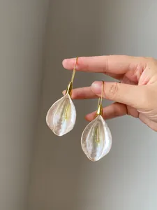 Detailed macro view of elegant petal-shaped earrings with pearlescent shell finish