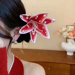 Vue détaillée de la pince à cheveux lys rouge en tissu avec perles sur modèle