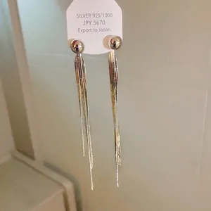 Orecchini pendenti lunghi con nappe in metallo argento dal design minimalista.