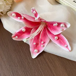 Gros plan détaillé d'une pince à cheveux lys en tissu rose avec des perles blanches