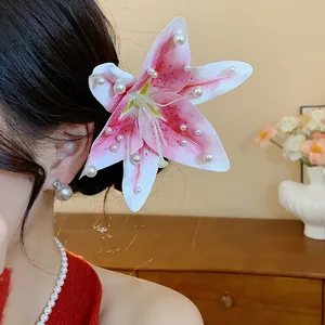 Détail d'une barrette fleur de lys rose en tissu avec des perles blanches élégantes
