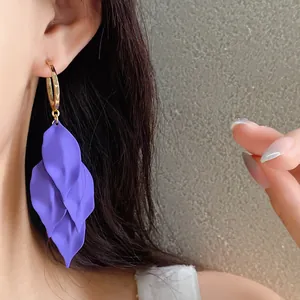 Detailed view of elegant purple petal tassel earrings worn by a model in close-up
