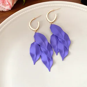 Detailed view of purple leaf tassel earrings with golden hoop studs and matte finish.