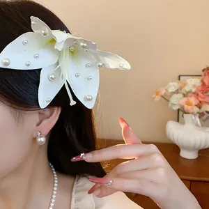 Élégante barrette à fleurs de lys en tissu avec des perles portée par un mannequin.
