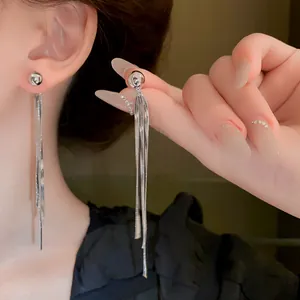 Eleganti orecchini pendenti a nappa d'argento su modella asiatica vista dettaglio