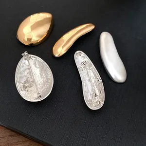 Vista dettagliata di spille geometriche in oro e argento, fronte e retro mostrati