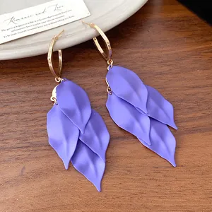 Detailed macro shot of matte purple leaf tassel earrings with elegant golden hoops