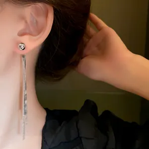 Primo piano di un orecchino a nappa lunga in argento con eleganti dettagli metallici.