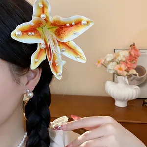 Gros plan d'une pince à cheveux lys en tissu avec d'élégantes perles blanches.