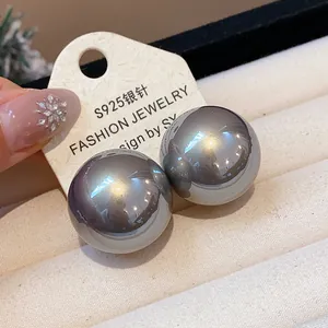 Dettaglio di grandi orecchini a lobo con perle grigie metallizzate e perni in argento S925