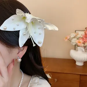 Gros plan sur une élégante pince à cheveux lis en tissu blanc avec perles