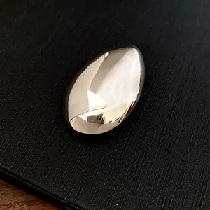 Vista dettagliata di una spilla minimalista a forma di goccia d'argento lucida e levigata