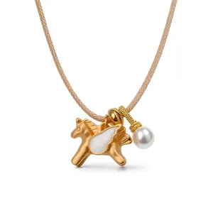 Élégant collier pégase doré avec ailes en émail et pendentif perle serti de zircons sur cordon beige.
