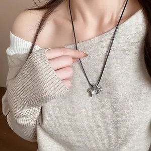 Modèle portant un collier avec pendentif cheval en zircon et perle sur un pull beige