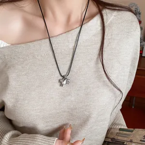 Détail d'un collier avec pendentif cheval minimaliste orné d'une perle et zircon