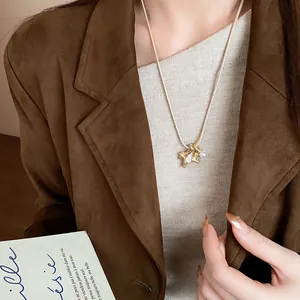 Gros plan d'un collier pendentif cheval doré élégant avec perle et zircon sur modèle