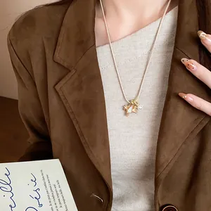 Gros plan d'un élégant collier pendentif cheval doré avec une perle et émail blanc