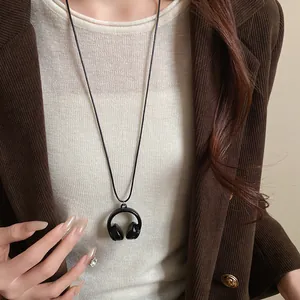 Nahaufnahme einer schwarzen Kopfhörer-Halskette kombiniert mit einem braunen Cord-Blazer