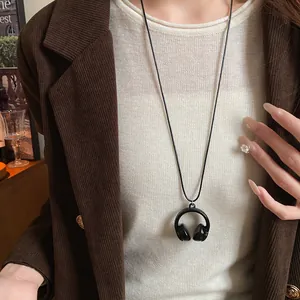 Detailaufnahme einer schwarzen Kopfhörer-Halskette zu einem braunen Cord-Blazer.