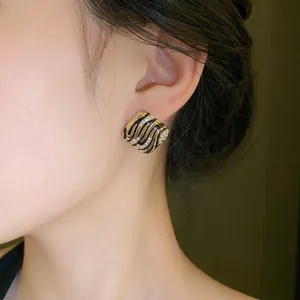 Elegant square gold-tone stud earrings with black enamel waves and sparkling rhinestones