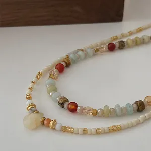 Macro detail of bohemian layered necklace with colorful crystal beads and stone pendant