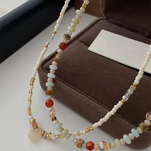 Macro detail of a layered necklace featuring colorful crystal and gold beads