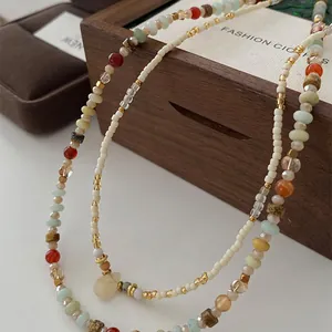 Detailed view of multilayered crystal and seed bead necklace on wooden background