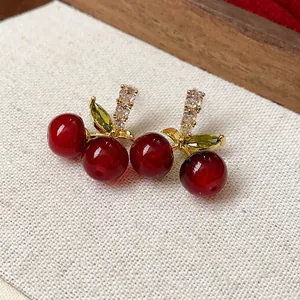 Elegant red resin cherry stud earrings with sparkling green zircons and silver needles