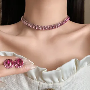 Primo piano di girocollo in strass rosa scintillante e orecchini abbinati sul modello.