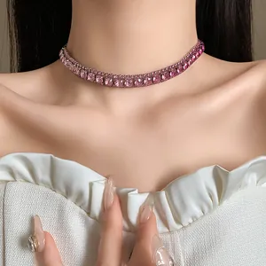 Primo piano di un elegante girocollo con strass quadrati rosa su modella.