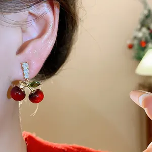 Detailed close-up of sweet resin cherry stud earrings with zircon accents on ear