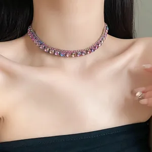 Primo piano di una collana choker con strass rosa brillanti indossata sul collo.