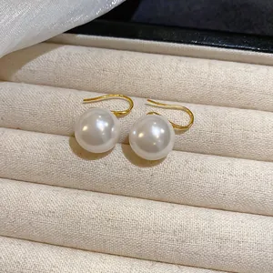 Elegant gold-plated hook earrings with large round white pearls in vintage style.