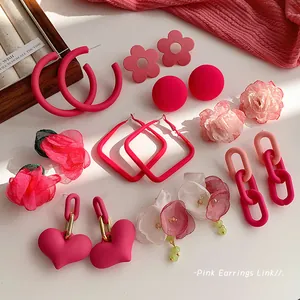 Assorted dopamine pink earrings including heart hoops, floral studs, and fabric flowers trend