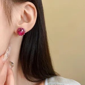 Elegante orecchino a bottone in cristallo rosa indossato da una modella per un look chic