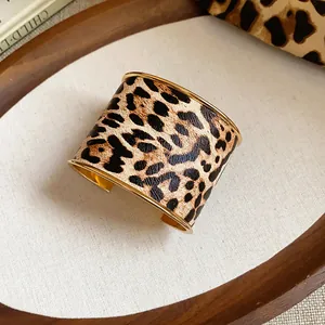 Detailansicht des breiten Armreifs mit Leopardenmuster und goldenen Metallkanten