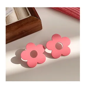 Detailed view of vibrant pink matte flower-shaped stud earrings with hollow center design