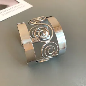 Exaggerated silver geometric cuff bracelet with spiral wire design in minimalist style