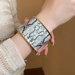 Detailansicht eines breiten Manschettenarmbands aus Leder mit Schlangenmuster.