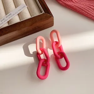 Detailed close-up of vibrant matte pink chain link drop earrings with soft natural lighting
