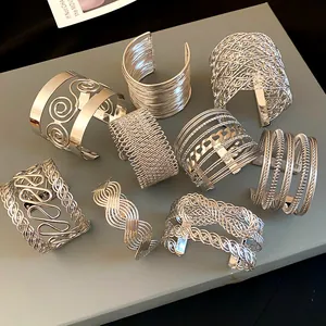 Detailed view of bold silver geometric cuff bracelets with woven patterns
