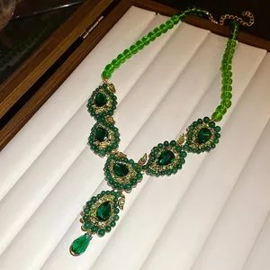 Nahaufnahme einer grünen Strass-Halskette im Vintage-Palaststil mit Tropfenanhänger