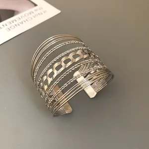 Detailed macro view of wide multi-layer silver cuff bracelet with geometric chain pattern
